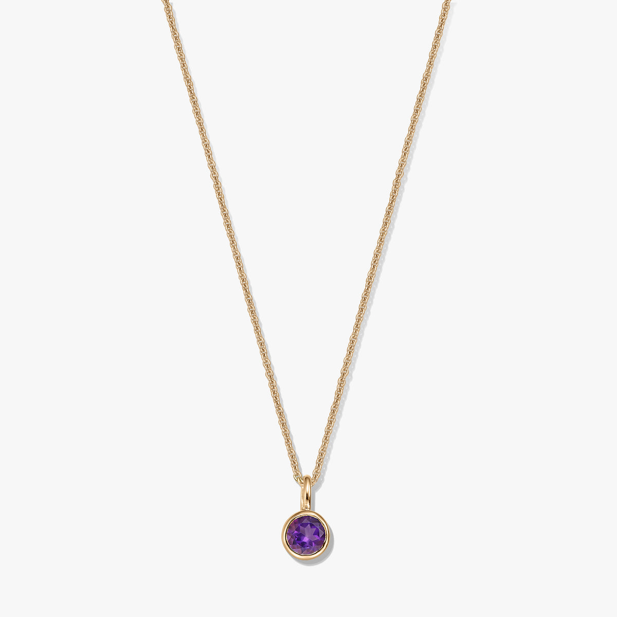 Collier en argent sterling plaqué or avec un petit pendentif rond en améthyste (pierre de naissance) sur fond blanc.