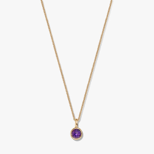 Collier en argent sterling plaqué or avec un petit pendentif rond en améthyste (pierre de naissance) sur fond blanc.