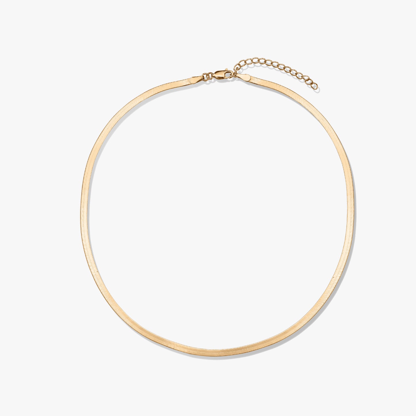 Collier en or à chevrons sur fond blanc.
