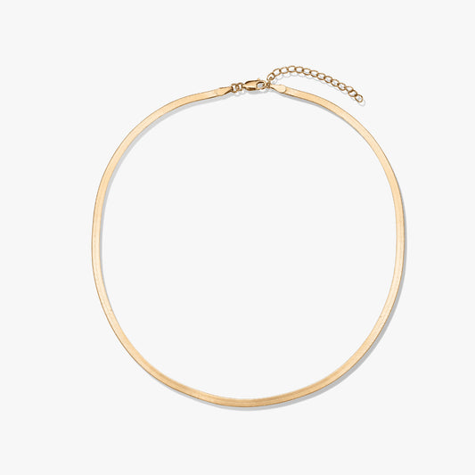Collier en or à chevrons sur fond blanc.