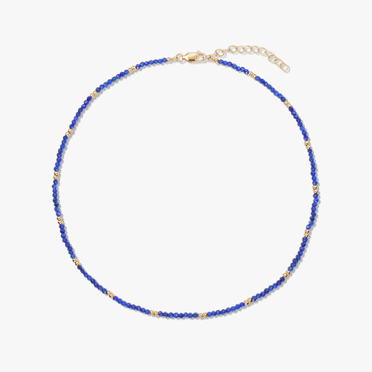 Collier délicat en perles de lapis-lazuli avec de petits détails en argent sterling plaqué or et un fermoir mousqueton réglable, isolé sur fond blanc.