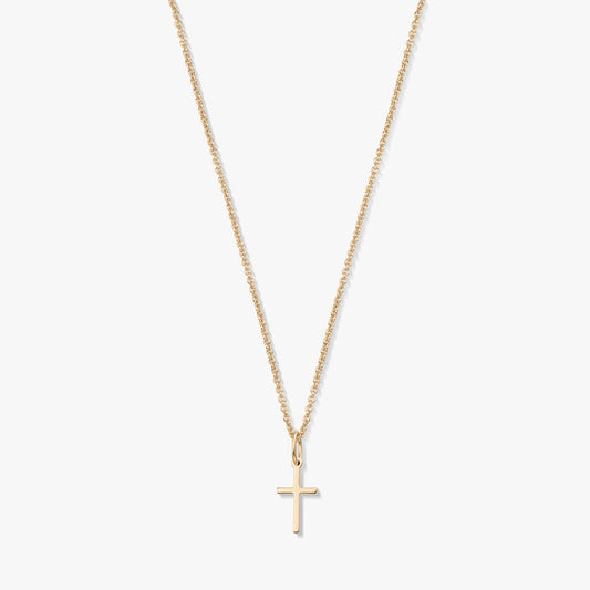Collier minimaliste en or jaune 14K avec un petit pendentif en forme de croix sur une fine chaîne, isolé sur fond blanc.
