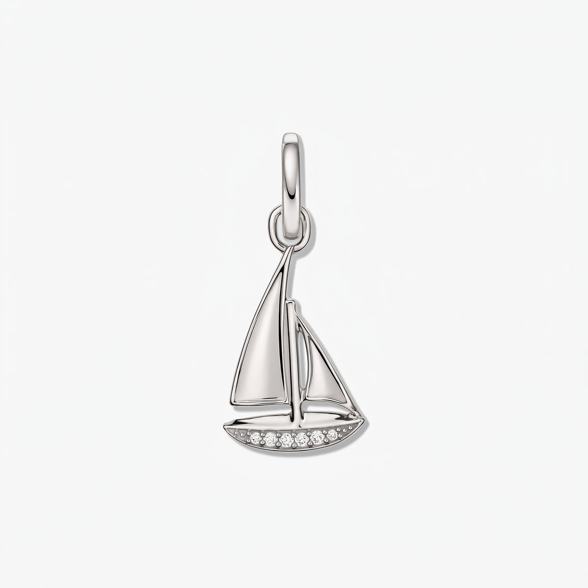Pendentif bateau à voile en argent sterling avec petits accents de zirconium blanc sur fond blanc.