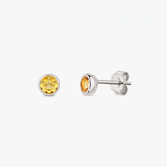 Paire de boucles d’oreilles clou en argent avec pierres de naissance en citrine rondes facettées, sur fond blanc, vues de face et de profil avec fermoirs papillon.