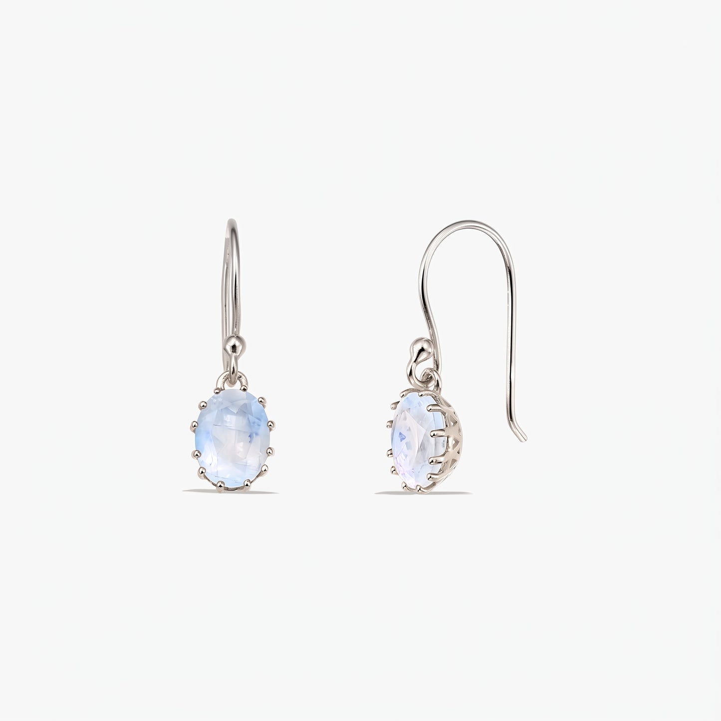 Paire de boucles d’oreilles pendantes en argent sterling, ornées de pierres de lune ovales facettées sur crochets français, présentées sur fond blanc (vues de face et de profil).