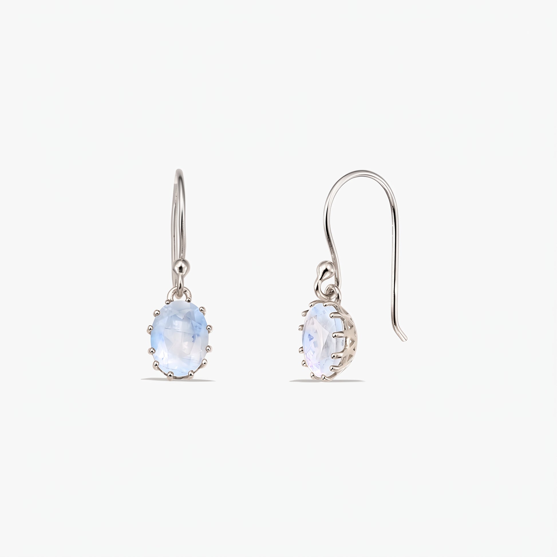 Paire de boucles d’oreilles pendantes en argent sterling, ornées de pierres de lune ovales facettées sur crochets français, présentées sur fond blanc (vues de face et de profil).