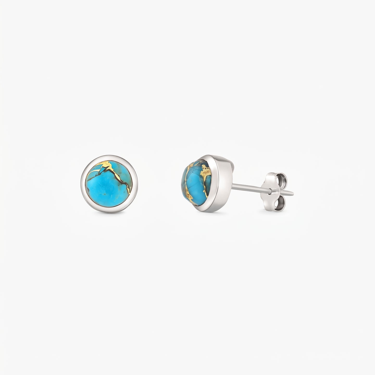 Paire de puces d’oreilles en argent sterling avec cabochons ronds de turquoise bleue cuivrée en serti clos, sur fond blanc.