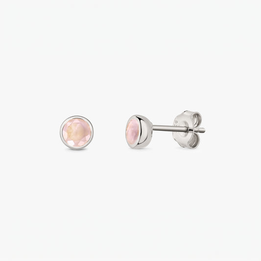 Paire de puces d’oreilles en argent sterling 925 avec pierres de quartz rose rondes facettées sur fond blanc, vues de face et de profil avec fermoirs papillon.