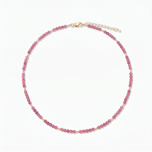 Collier en argent Golden SummerScape - Tourmaline par Indira : collier de perles de tourmaline rose avec de petits accents dorés et un fermoir mousqueton avec rallonge, sur fond blanc.