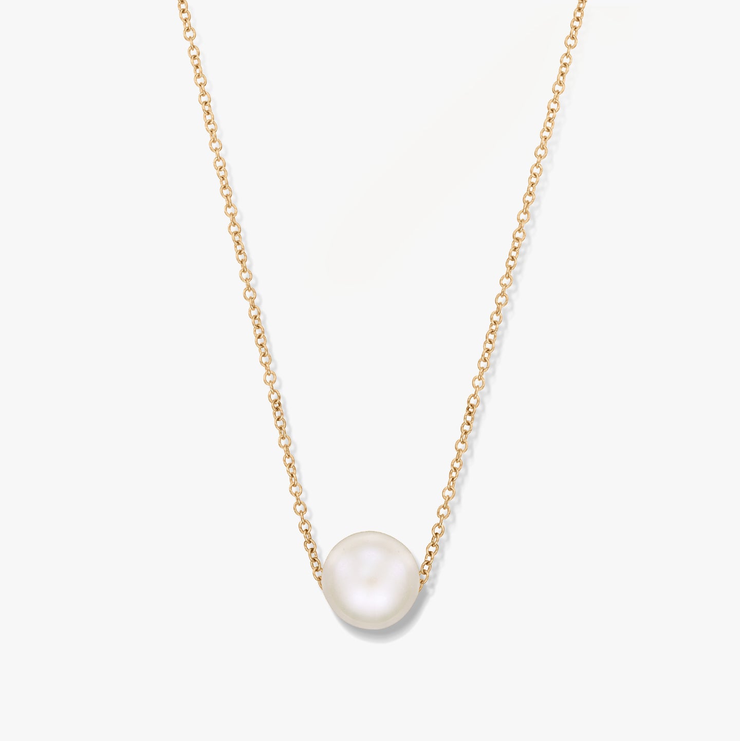 Un collier en or avec un pendentif perle unique sur fond blanc.