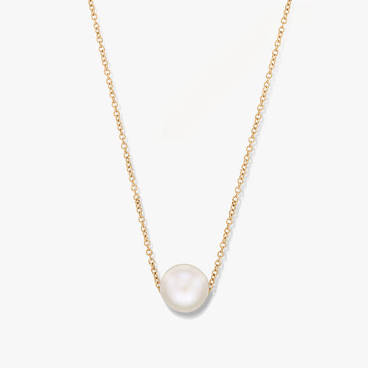 Un collier en or avec un pendentif perle unique sur fond blanc.